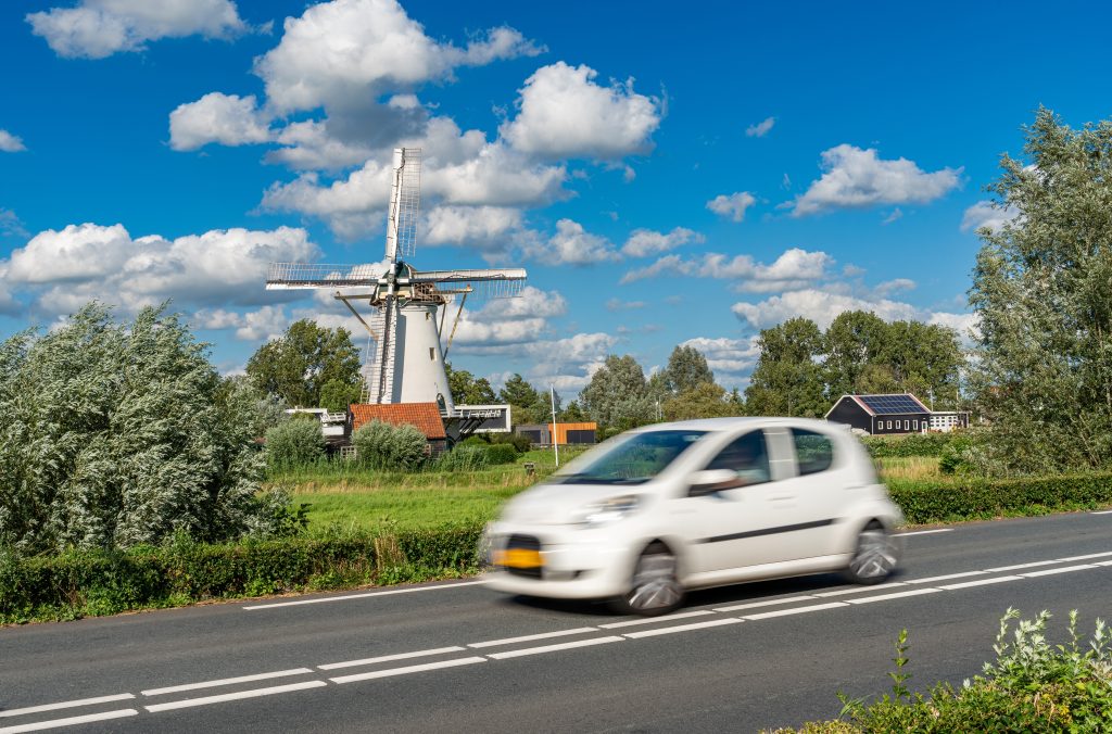 Auto rijdt langs een molen